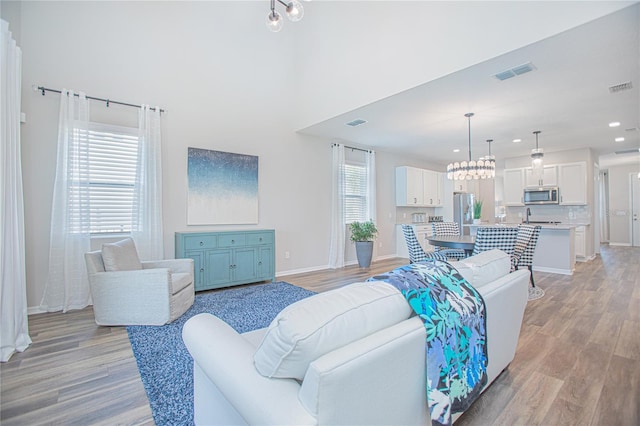 living room with light hardwood / wood-style flooring and a notable chandelier