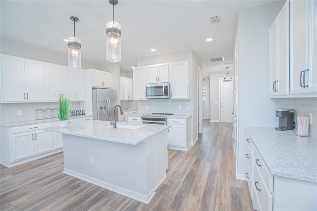 kitchen featuring sink, hanging light fixtures, stainless steel appliances, white cabinets, and light wood-type flooring