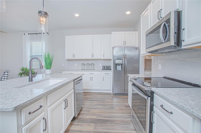 kitchen with sink, stainless steel appliances, light hardwood / wood-style floors, decorative backsplash, and white cabinets