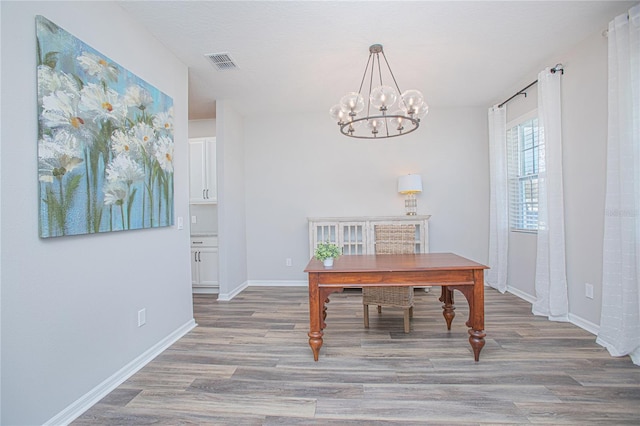 home office with a notable chandelier and hardwood / wood-style flooring