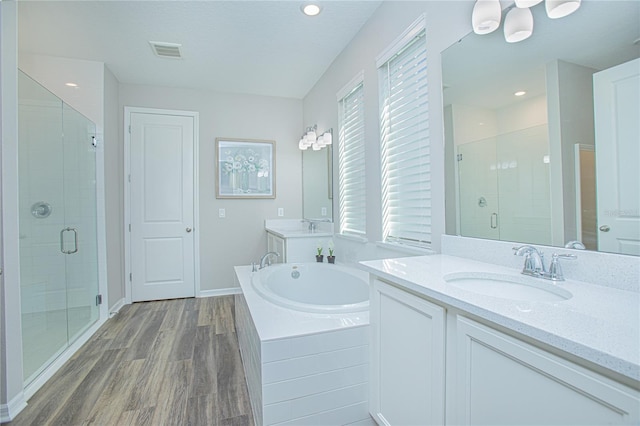 bathroom with hardwood / wood-style flooring, vanity, and separate shower and tub