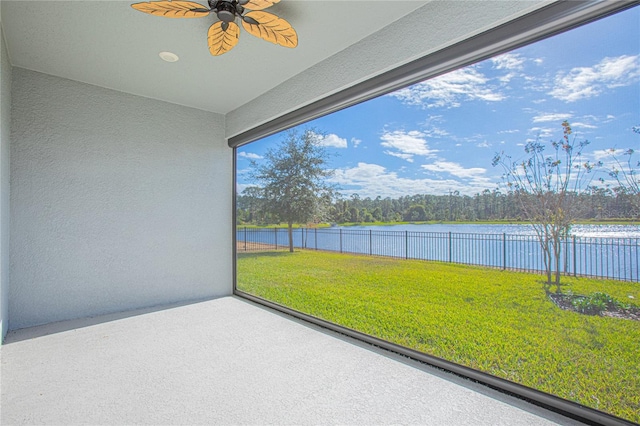 unfurnished sunroom featuring a water view and ceiling fan