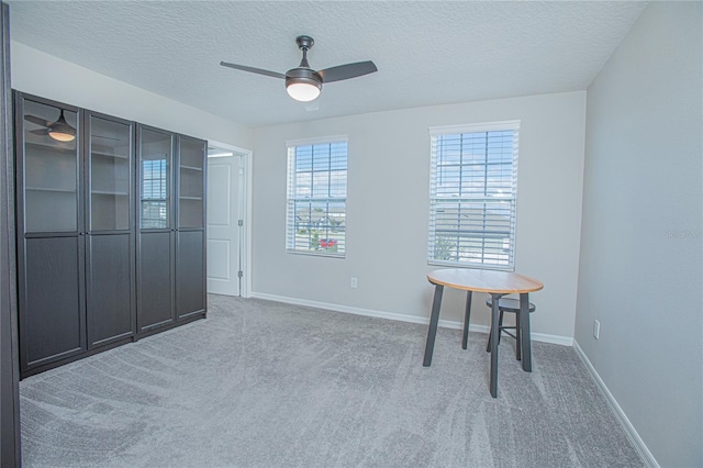 carpeted spare room with ceiling fan and a textured ceiling