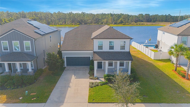 view of front of home featuring a water view, a garage, and a front lawn