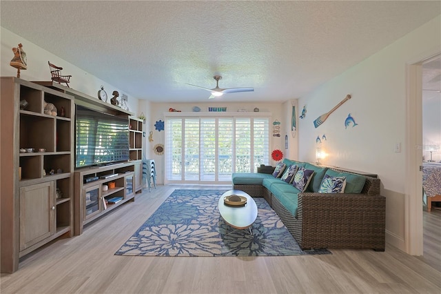 living room featuring a textured ceiling, ceiling fan, and light hardwood / wood-style flooring