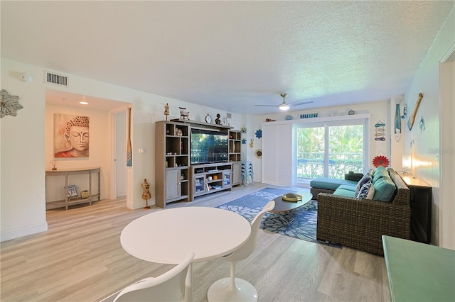 living room featuring hardwood / wood-style floors, a textured ceiling, and ceiling fan