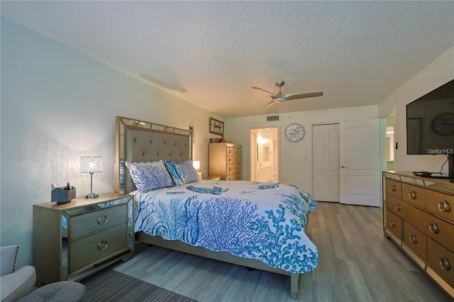 bedroom featuring a closet, ceiling fan, hardwood / wood-style floors, and a textured ceiling