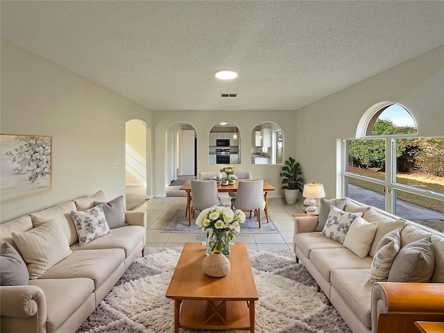 tiled living room featuring a textured ceiling