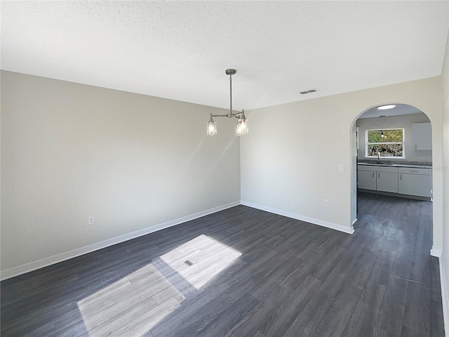 unfurnished dining area with dark hardwood / wood-style floors, sink, and a textured ceiling