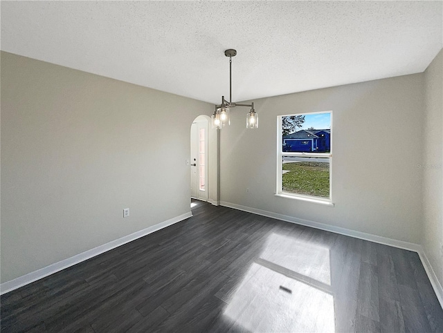 unfurnished dining area featuring dark wood-type flooring and a textured ceiling