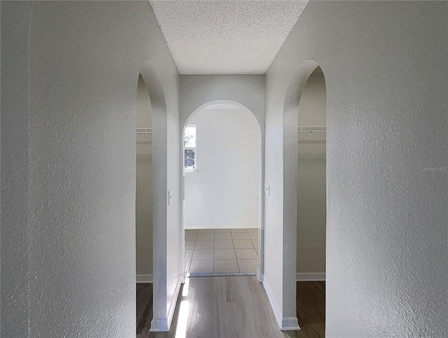 hallway featuring hardwood / wood-style floors and a textured ceiling