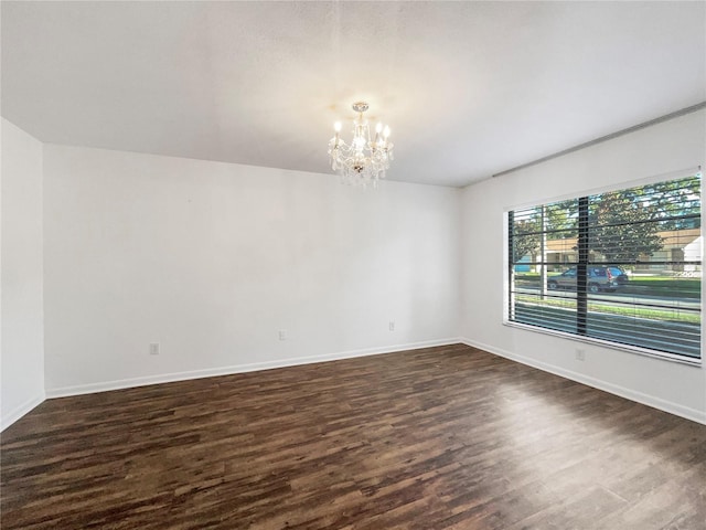 unfurnished room with dark wood-type flooring and a notable chandelier