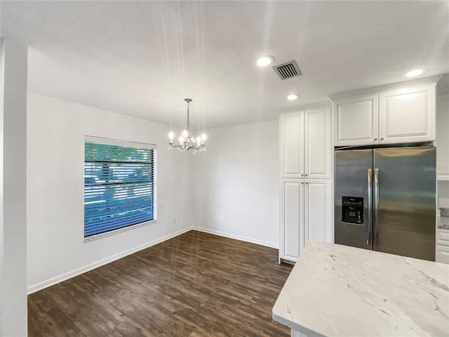 kitchen with white cabinetry, hanging light fixtures, dark hardwood / wood-style flooring, a notable chandelier, and stainless steel fridge