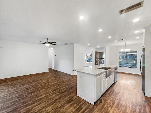 kitchen featuring a kitchen island with sink, sink, dark hardwood / wood-style floors, decorative light fixtures, and white cabinetry