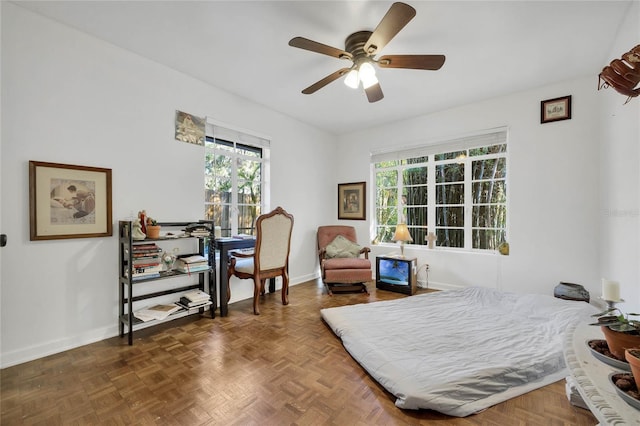 bedroom with ceiling fan and dark parquet floors