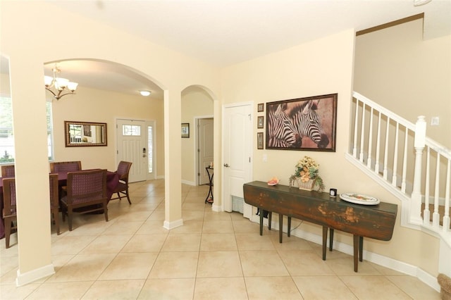 hall with light tile patterned floors and a notable chandelier