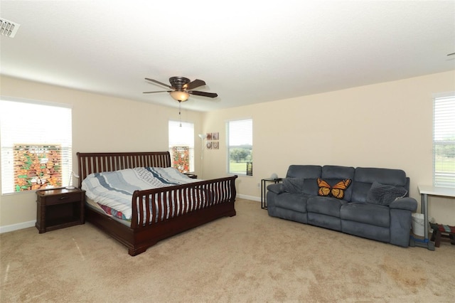 carpeted bedroom with multiple windows and ceiling fan