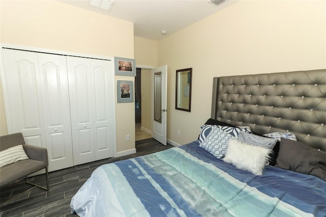 bedroom with dark hardwood / wood-style flooring and a closet