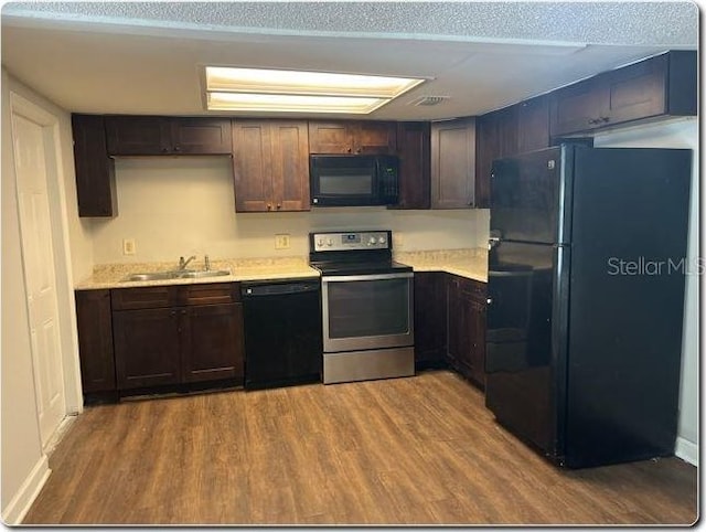 kitchen featuring black appliances, dark brown cabinetry, sink, and hardwood / wood-style floors