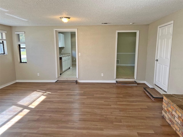 empty room featuring a textured ceiling and light wood-type flooring