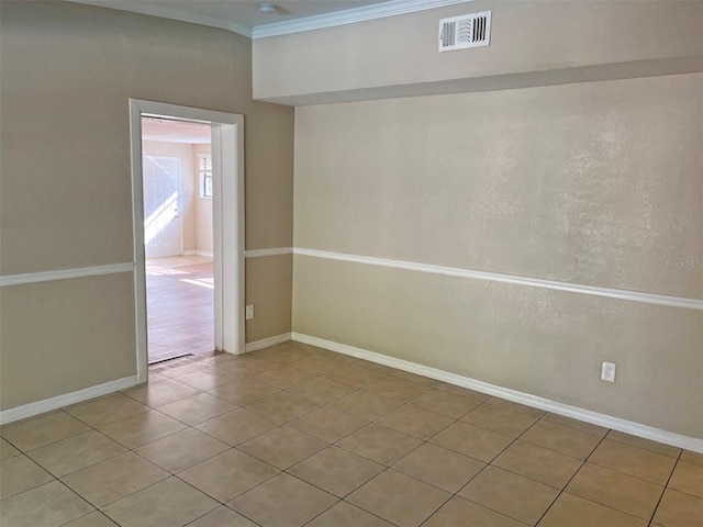 tiled empty room featuring crown molding