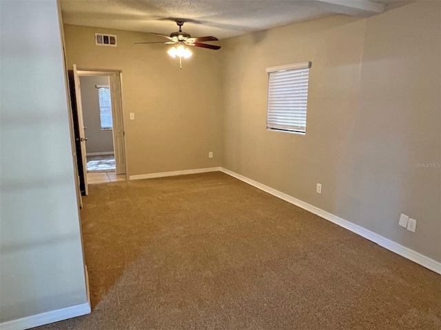 carpeted empty room with ceiling fan and a textured ceiling