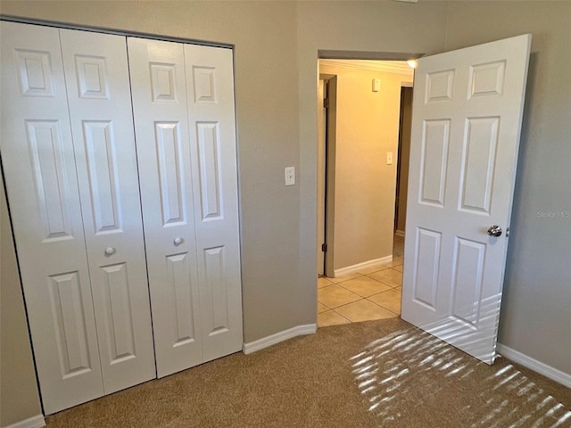 unfurnished bedroom featuring light colored carpet and a closet