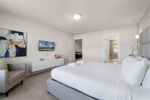 bedroom featuring ensuite bath and light colored carpet