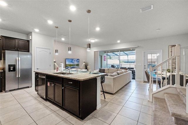 7420 Oakmoss Loop, Davenport, FL 33837 - kitchen with appliances with stainless steel finishes, open floor plan, a sink, a kitchen island with sink, and recessed lighting
