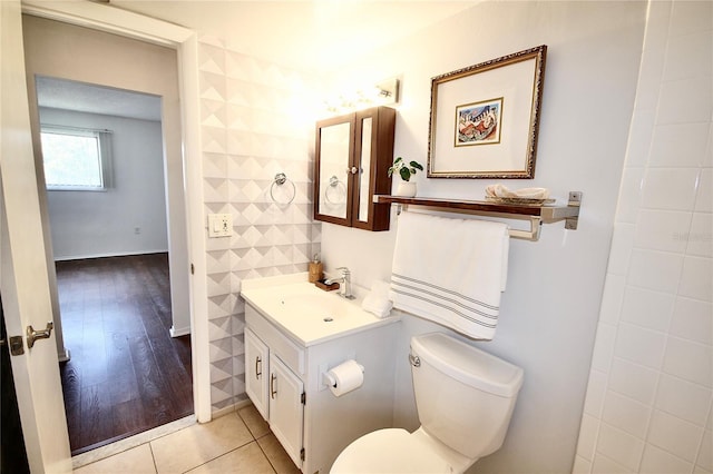 bathroom with vanity, wood-type flooring, tile walls, and toilet