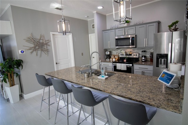 881 Orchid Grove Blvd, Davenport, FL 33837 - kitchen with appliances with stainless steel finishes, gray cabinets, backsplash, ornamental molding, and dark stone counters
