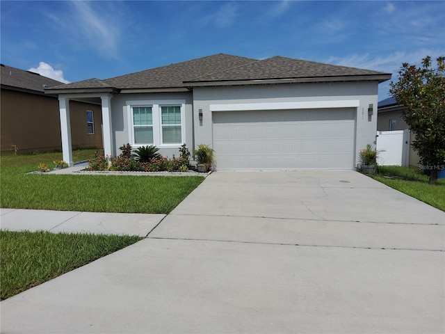 881 Orchid Grove Blvd, Davenport, FL 33837 - view of front facade with stucco siding, an attached garage, concrete driveway, roof with shingles, and a front lawn