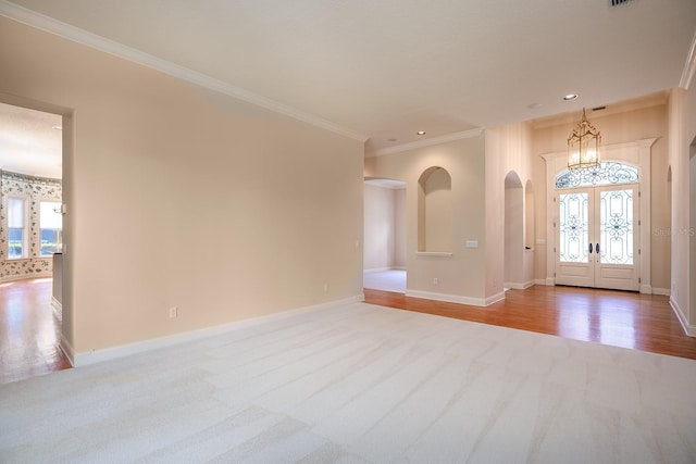 foyer with crown molding, plenty of natural light, light hardwood / wood-style floors, and french doors