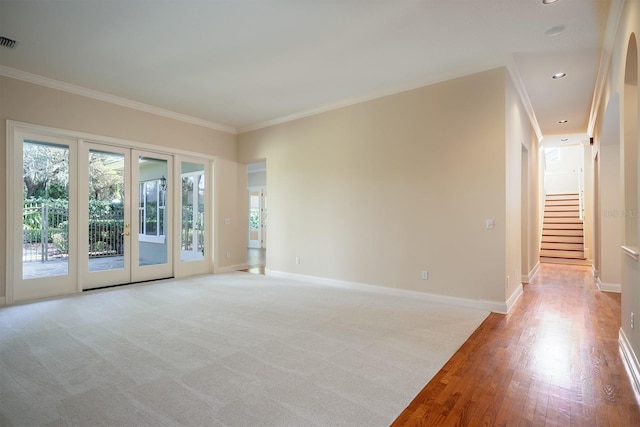 unfurnished room featuring french doors, light wood-type flooring, and ornamental molding