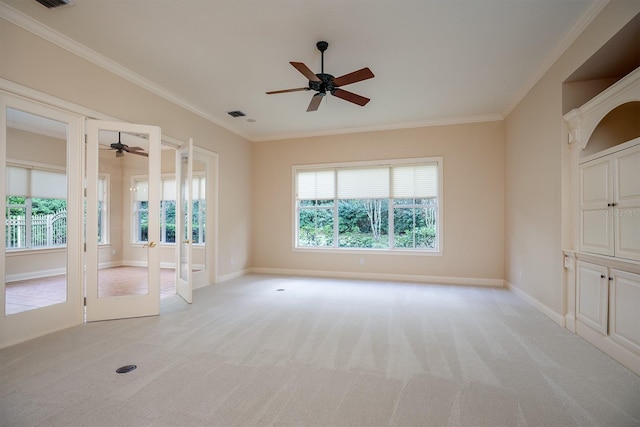 carpeted empty room with crown molding, french doors, and ceiling fan