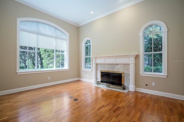 unfurnished living room with a tile fireplace, light hardwood / wood-style flooring, and ornamental molding