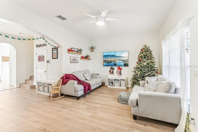 living room with light hardwood / wood-style floors and ceiling fan