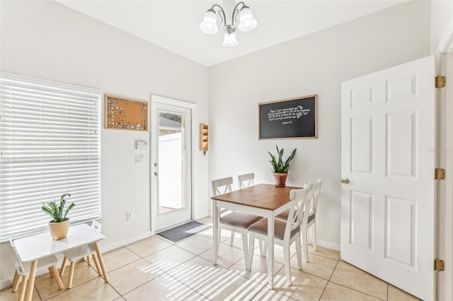 dining area with light tile patterned flooring and a chandelier