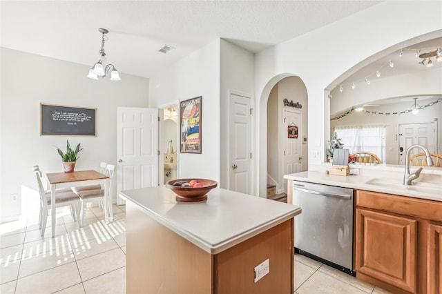 kitchen featuring a center island, sink, hanging light fixtures, stainless steel dishwasher, and a notable chandelier