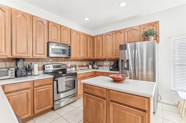 kitchen featuring decorative backsplash, appliances with stainless steel finishes, and light tile patterned floors