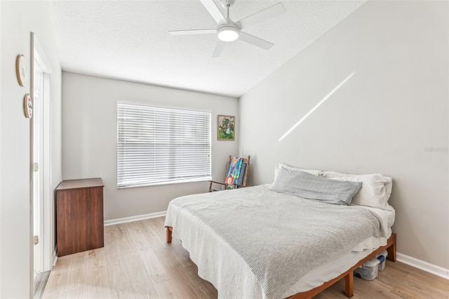 bedroom featuring a textured ceiling, light hardwood / wood-style floors, and ceiling fan