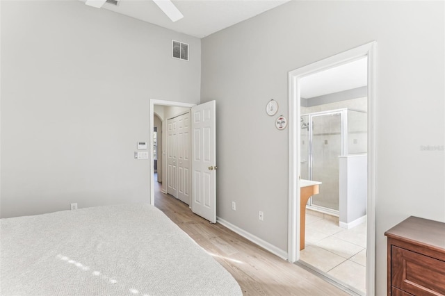 bedroom featuring connected bathroom, ceiling fan, and light wood-type flooring