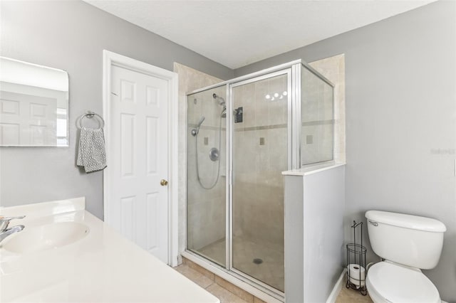 bathroom featuring an enclosed shower, vanity, a textured ceiling, tile patterned flooring, and toilet