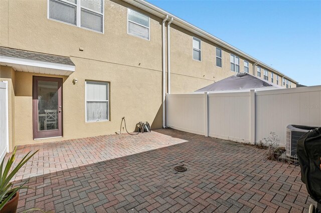 rear view of house featuring a patio and central air condition unit