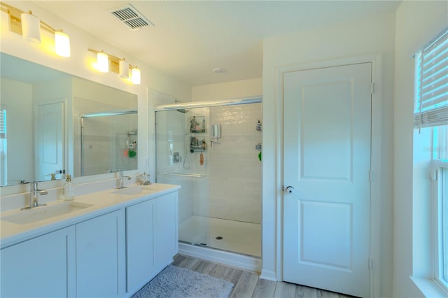 bathroom featuring vanity, hardwood / wood-style flooring, and a shower with shower door