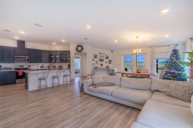 living room featuring a chandelier and light hardwood / wood-style floors