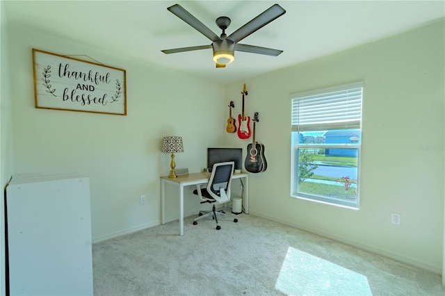 office space featuring light carpet and ceiling fan