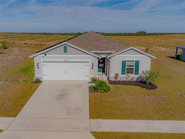 single story home with a rural view, a garage, and a front lawn