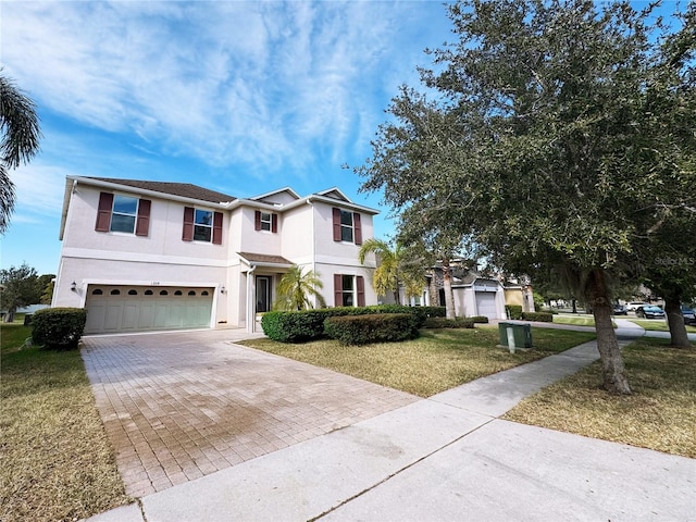 1208 Sawgrass Pointe Dr, Orlando, FL 32824 - traditional-style house with a front lawn, decorative driveway, stucco siding, and a garage