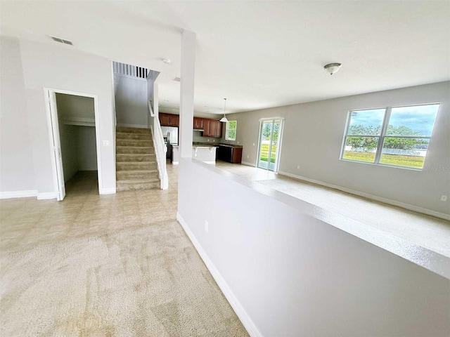 1208 Sawgrass Pointe Dr, Orlando, FL 32824 - unfurnished living room with light carpet, stairs, baseboards, and visible vents